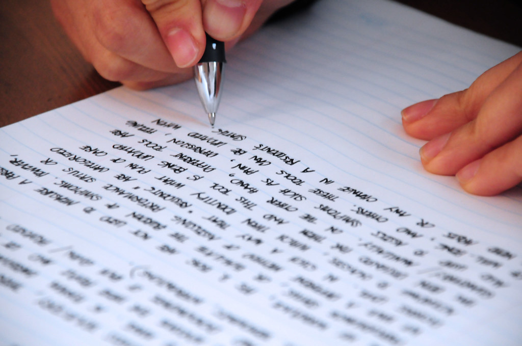 Lined paper notebook with a hand writing in black ink.