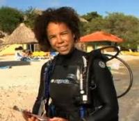 Photograph of Dr. Ayana Johnson in scuba gear at a beach.