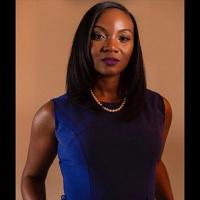 Dr. Kizzmekia Corbett in a blue dress and pearl necklace, looking at the camera.