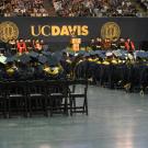 UC Davis commencement floor, filled with graduating students in caps and gowns